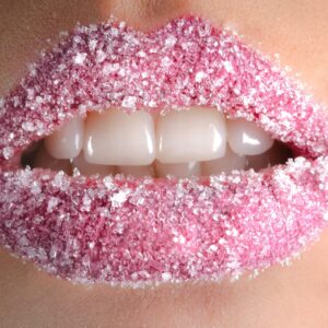 Artistic close-up of lips coated with pink sugar crystals, showcasing beauty and creativity.
